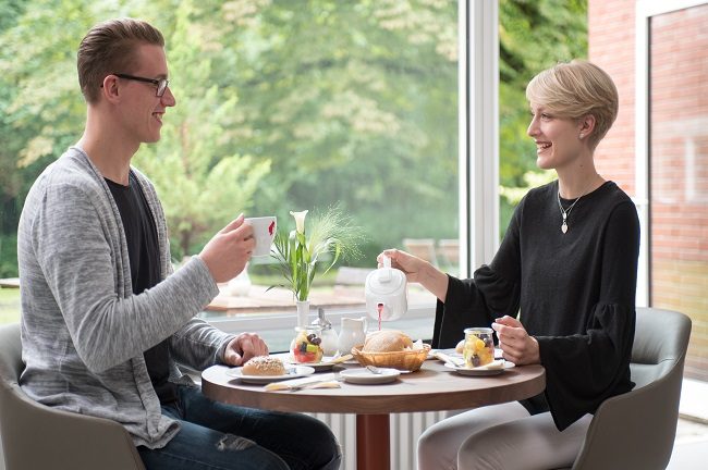 Zwei Hotelgäste frühstücken gemeinsam am Tisch