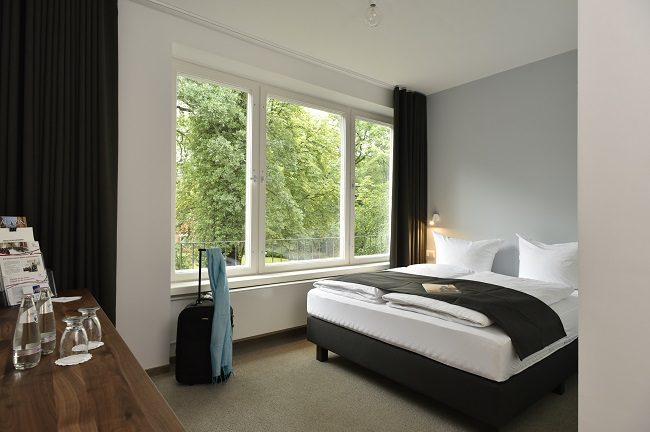Großes Doppelbett Zimmer mit Blick ins Grüne.